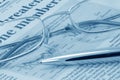 Business press, glasses and pen (blue toned) Royalty Free Stock Photo