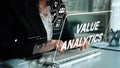 Business professional analyzing data and value metrics with a digital interface showing analytics and graphs. Asymptotic Royalty Free Stock Photo
