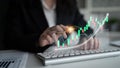 Business Professional Analyzing Financial Data Graph on Keyboard with Digital Stock Market Chart Displayed in Background Royalty Free Stock Photo