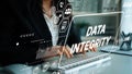 Business Professional Emphasizing Data Integrity with Digital Overlay of Technology Icons and Analytics in Office Royalty Free Stock Photo