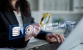 Business professional examining data analytics on low code platform with magnifying glass and modern technology Royalty Free Stock Photo