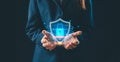Business professional holding glowing holographic shield with lock icon, symbolizing cybersecurity protection, secure systems, Royalty Free Stock Photo