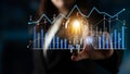 Business professional holding light bulb with glowing filament and digital data analytics graphics depicting growth and Royalty Free Stock Photo