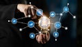 Business Professional Holding Light Bulb with Technology Icons Representing Innovation, Data Analysis, and Connections Royalty Free Stock Photo