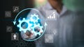 A business professional interacts with a digital workflow interface featuring glowing gears, process arrows, and analytical icons Royalty Free Stock Photo