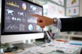Business professional in a suit pointing at a computer screen displaying colorful data visualizations and graphs, illustrating Royalty Free Stock Photo
