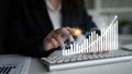 Business professional using computer keyboard with graph overlay depicting growth and success in financial metrics and Royalty Free Stock Photo
