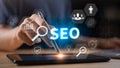 Business professional using digital tablet with glowing SEO text, analytics icons ,data visualization. Concept of search engine Royalty Free Stock Photo
