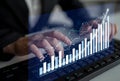 Business Professional Using Keyboard with Graphs and Charts Displayed on Transparent Screen in Modern Office Environment Royalty Free Stock Photo