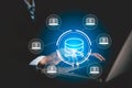 Business professional working on laptop, glowing database access interface connected to multiple devices, symbolizing Royalty Free Stock Photo