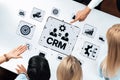 Business professionals collaborating on CRM strategies with digital icons and graphics emphasizing data analysis and Royalty Free Stock Photo