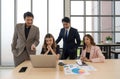 Business professionals collaborating with enthusiasm while examining data on a laptop in a contemporary office setting Royalty Free Stock Photo