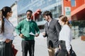 Business professionals discussing work outdoors in a city on a sunny day