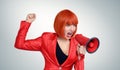 Business redhead woman in red screaming into a megaphone Royalty Free Stock Photo