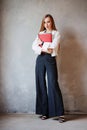 Business redhead woman in white shirt and black pants with folders of documents. Royalty Free Stock Photo