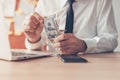 Business revenue, businessman counting US dollar cash money in office