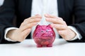 Business savings concept - businesswoman covering piggy bank wit Royalty Free Stock Photo