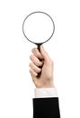 Business Search topic: businessman in a black suit holding a magnifying glass on a white isolated background