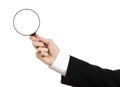 Business Search topic: businessman in a black suit holding a magnifying glass on a white isolated background