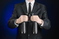 Business and search topic: Man in black suit holding a black binoculars in hand on a dark blue background in studio isolated Royalty Free Stock Photo