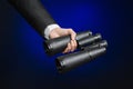 Business and search topic: Man in black suit holding a black binoculars in hand on a dark blue background in studio isolated Royalty Free Stock Photo