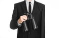 Business and search topic: Man in black suit holding a black binoculars in hand on white isolated background in studio Royalty Free Stock Photo