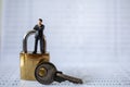 Business and Security Concept. Businessman miniature figure people standing on gold master key lock with silver key on bank