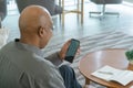 Business senior old elderly Black American man, African person using a smartphone or mobile phone with blank screen space on Royalty Free Stock Photo