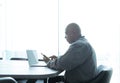 Business senior old elderly Black American man, African person using a smartphone or mobile phone in living room at home in Royalty Free Stock Photo