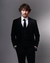 Business sexy man in black fashion suit posing on gray bacground with serious face and passion angry look. Closeup Royalty Free Stock Photo