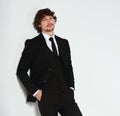 Business sexy man in black fashion suit posing on gray wall bacground with smiling happy face. Closeup studio Royalty Free Stock Photo