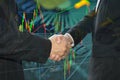 Business shaking hand on finacial graph background.