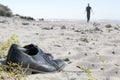 Business shoes at the beach and a blurred man walking away to th Royalty Free Stock Photo