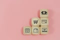 Business shopping online concept, wooden cubes block with shopping icons, e-business purchase marketing consumer pink background Royalty Free Stock Photo