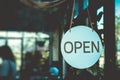 A business sign that says open on cafe or restaurant hang on door at entrance