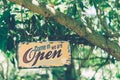 A business sign that says open on cafe or restaurant hang on door at entrance. Vintage color tone style Royalty Free Stock Photo