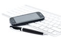 Business smartphone on the keyboard, with pen Royalty Free Stock Photo