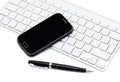Business smartphone on the keyboard, with pen Royalty Free Stock Photo