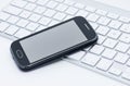Business smartphone on the keyboard Royalty Free Stock Photo