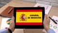 Business Spanish application against flag on tablet in female hands, tutorial Royalty Free Stock Photo