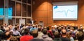 Business speaker giving a talk in conference hall.