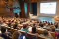 Business speaker giving a talk in conference hall.