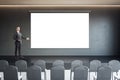 Business speaker on the scene near blank white screen for advertising text, campaign or logo brand on dark wall background in