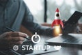 Business startup concept with a rocket icon launching from a laptop