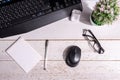 Business still life: a home flower, a white notepad, glasses and a black pen on the table next to a black computer keyboard and a Royalty Free Stock Photo