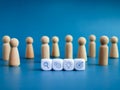 Business strategy and action plan icons on white cube blocks surrounded with wooden human figures on blue background. Royalty Free Stock Photo