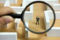 Business strategy conceptual photo - Miniature of businessman looking for solution on a labyrinth maze