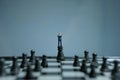 Miniature businessman standing above castle pawn in the middle of chessboard