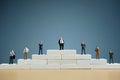 Miniature of businessman stands on staircase podium