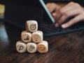 Business strategy icons on wooden cube blocks pyramid steps on desk near person work with digital tablet computer. Royalty Free Stock Photo